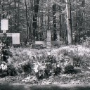 Auf einem improvisierten individuellen Trauerplatz in der NMG Buchenwald erinnern Angehörige mit Holzkreuzen und Suchlisten der Toten des Speziallagers Nr. 2, Mai 1990. Foto: Stiftung Gedenkstätten Buchenwald und Mittelbau-Dora (SGBUMD)