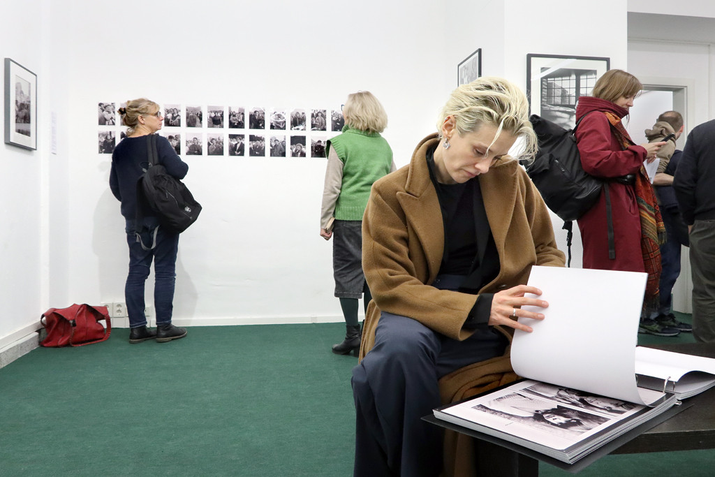 Besucherin beim Blättern in einer Reproduktion von Margit Emmrichs Arbeit „Die Zeit dazwischen – Dokumente zur Pubertät“ © Nihad Nino Pusija.